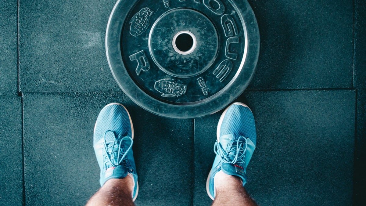 person standing beside black weights